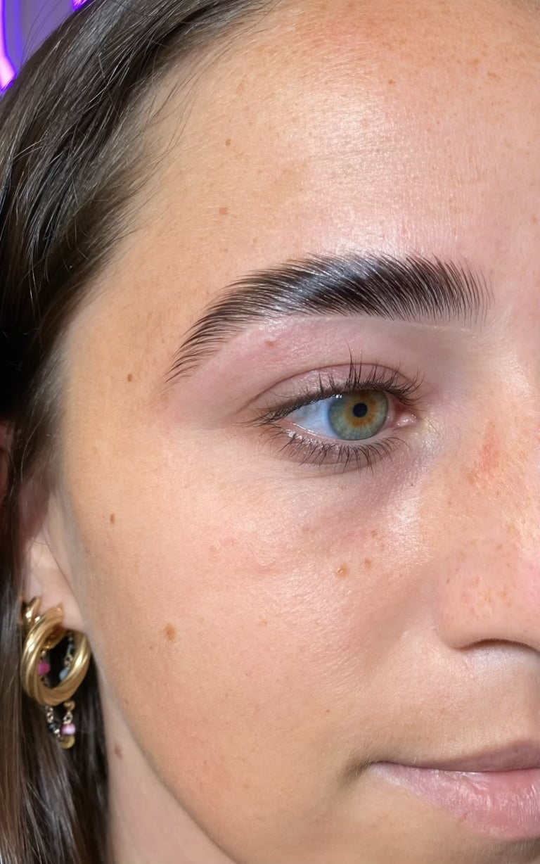 Close-up of a person's eye with a focus on the eyebrow area.