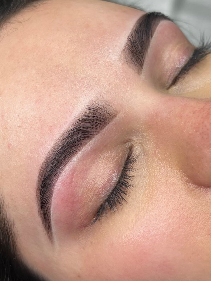 Close-up of a person's eye with well-groomed eyelashes and eyebrows.