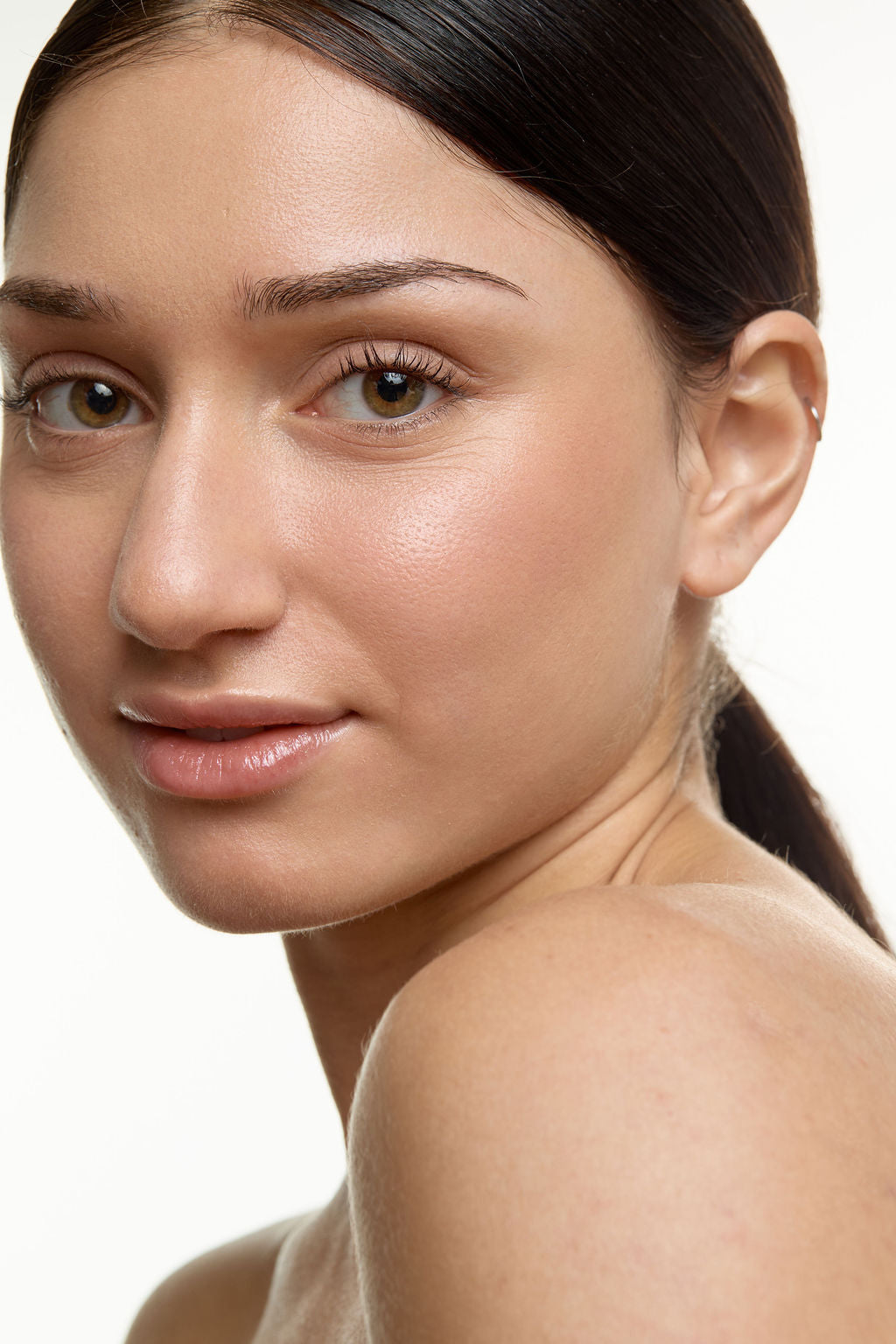Close-up of a woman's face with a neutral expression on a white background