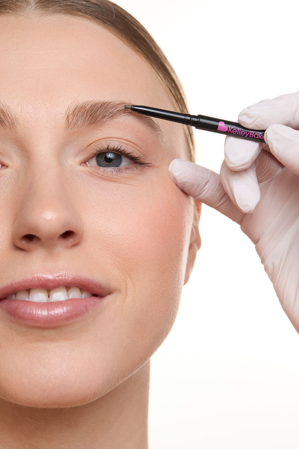 Person applying makeup to eyebrows with a brush, wearing gloves.