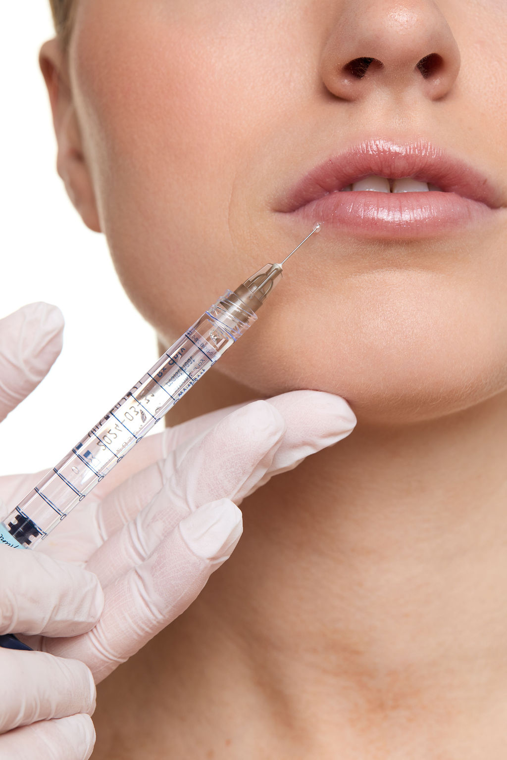Close-up of a person receiving a facial injection with a syringe.
