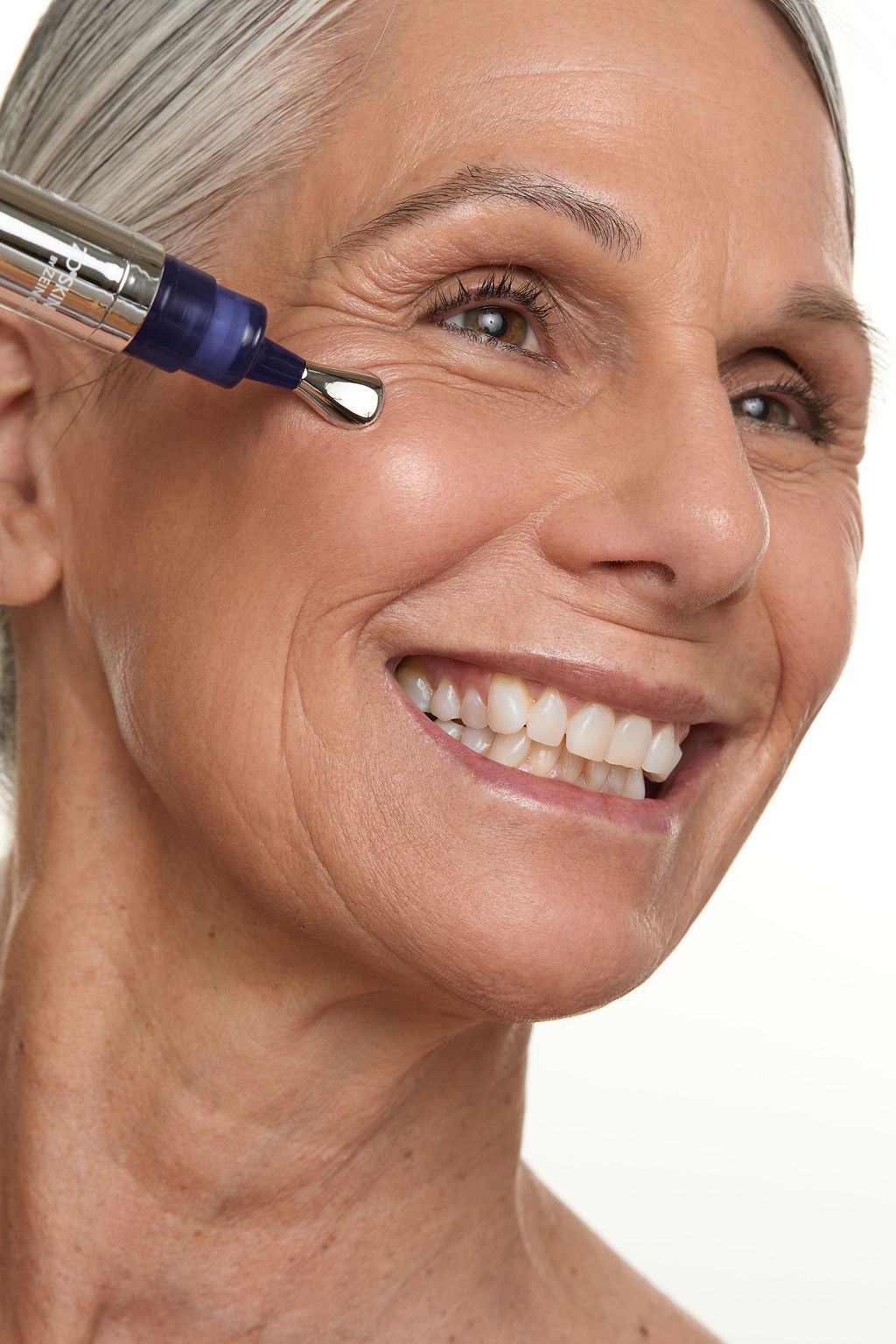 Woman using skin care pen on her face.
