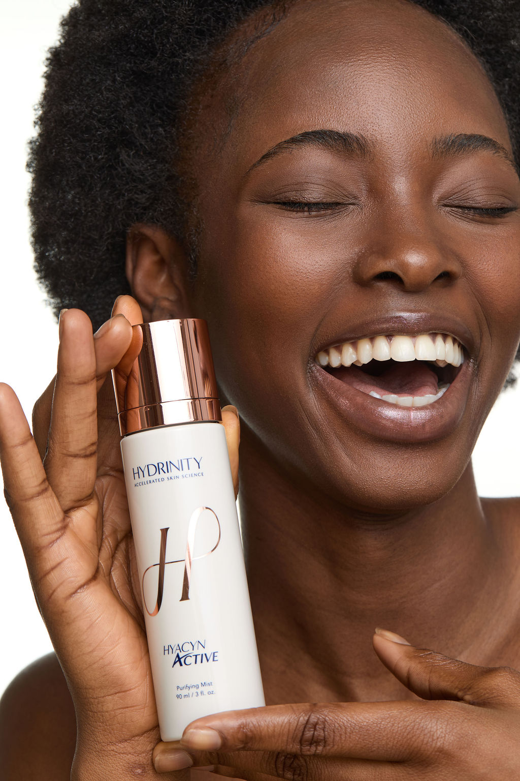 Woman holding a skincare product with 'Hydrinity' branding