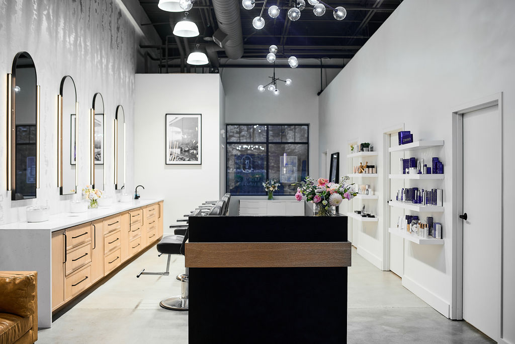 Modern interior design of a med spa with white walls, wooden vanity, and decorative elements.
